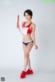 A woman in a red and blue bikini holding a red baton.